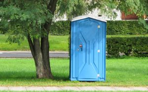 deluxe portable toilet on a grassy lot
